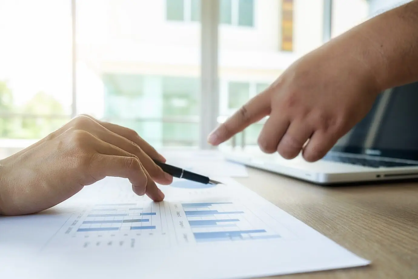 Eine Geschäftsperson arbeitet in einem Unternehmen mit Wirtschafts- und Finanzunterlagen.